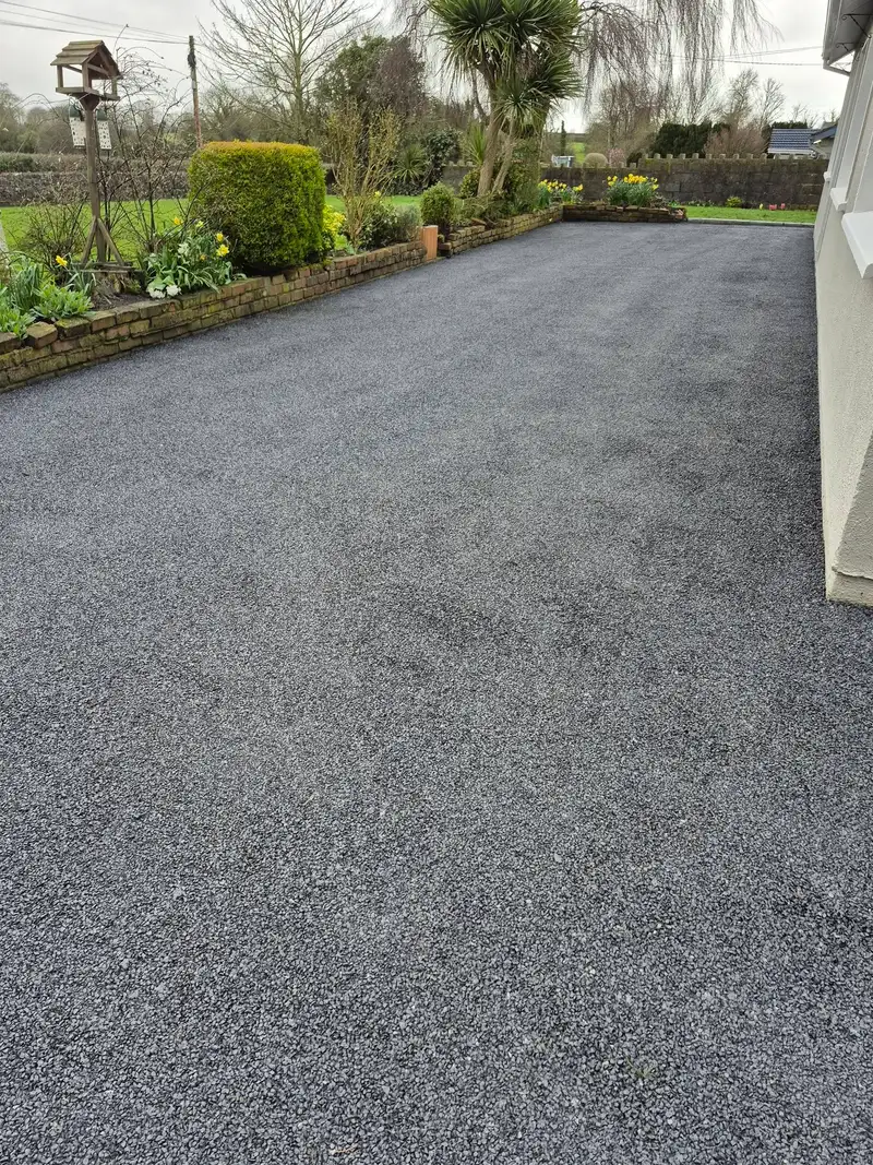 tar and chip driveway installation at the side of a house
