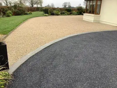 image of house with a black and gold tar and chip driveway with kerb edging in the middle