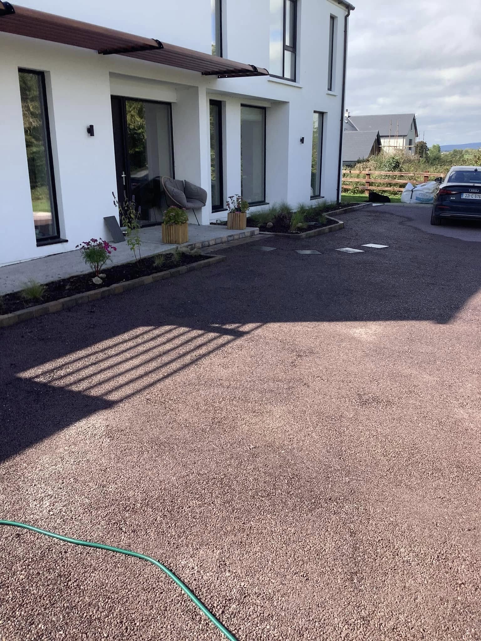 image of a driveway with a red chip coloured stone on it.