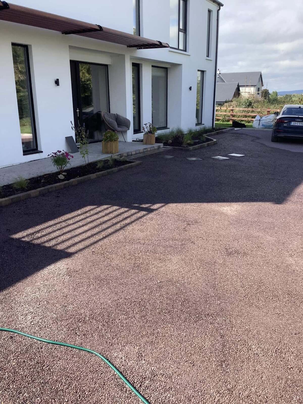 front of a house with fresh tar and chip installation