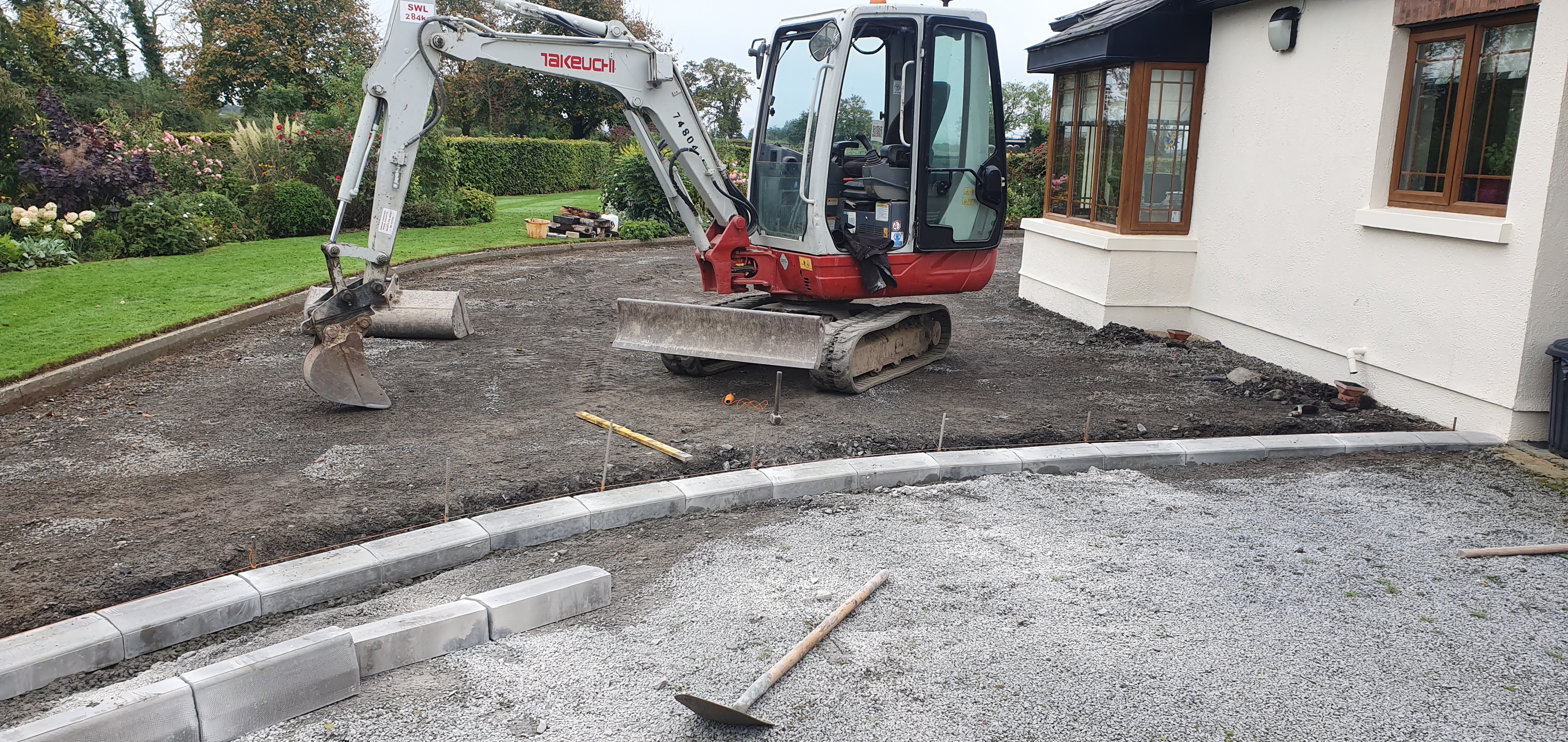 A Downey Construction Digger performing ground work outside the back garden of a house