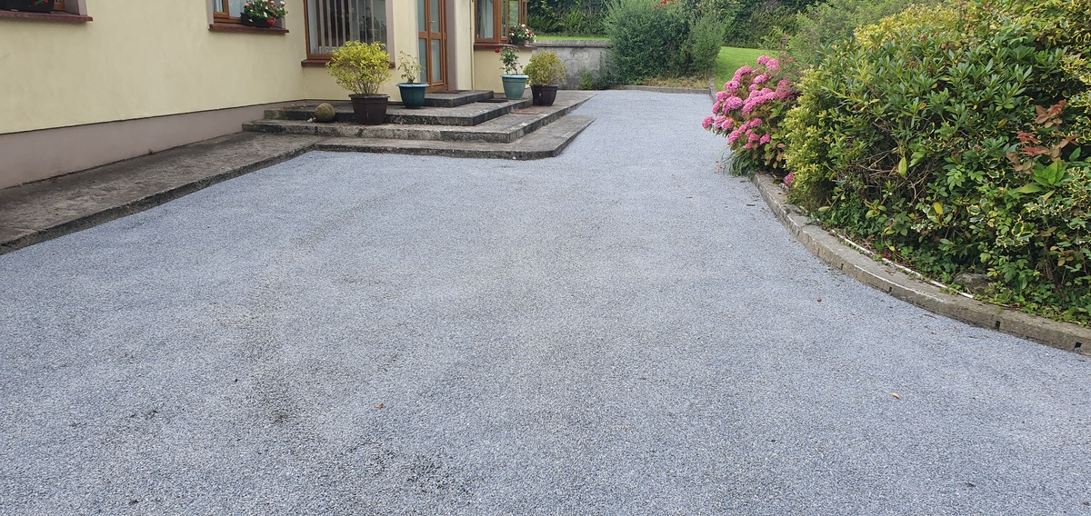 grey coloured tar and chip driveway installation at front of house